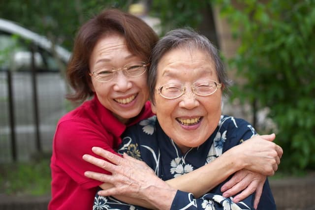 A daughter hugging her laughing mother